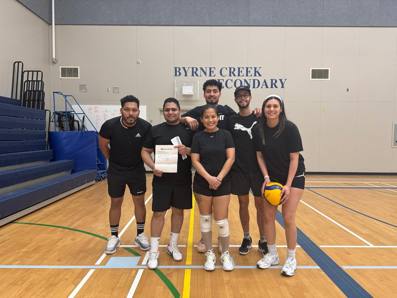 The original Prime Hotshots volleyball group together inside the Byrne Creek Secondary gymnasium